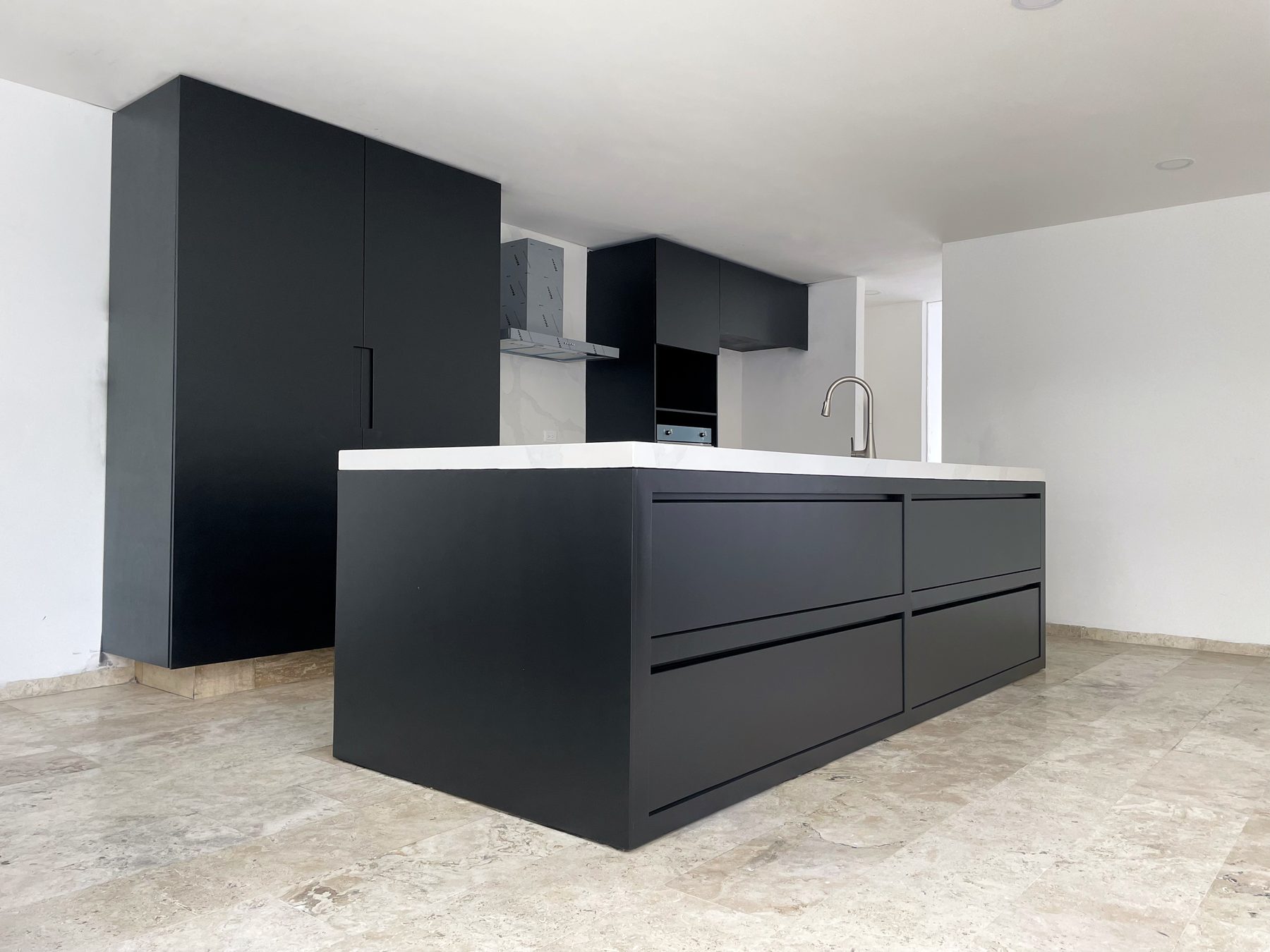 Cocina residencial con isla y alacenas en negro mate y cubierta blanca