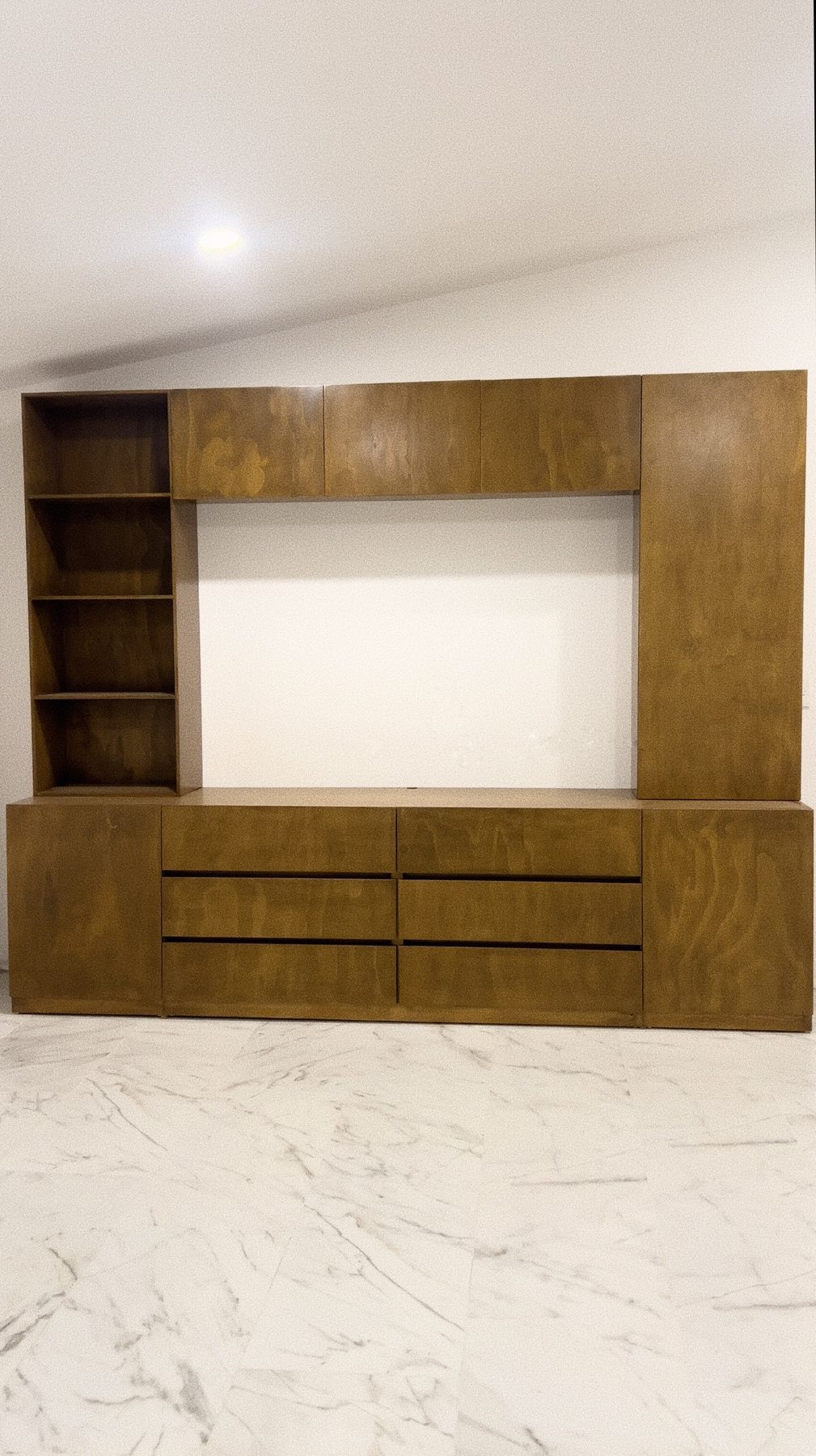 Mueble de TV a medida en madera tono miel con cajones y librero lateral